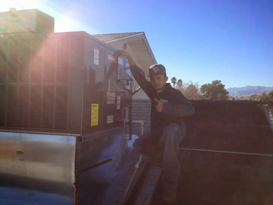 HVAC technician performing Air Duct Cleaning on a rooftop unit in Palmetto
