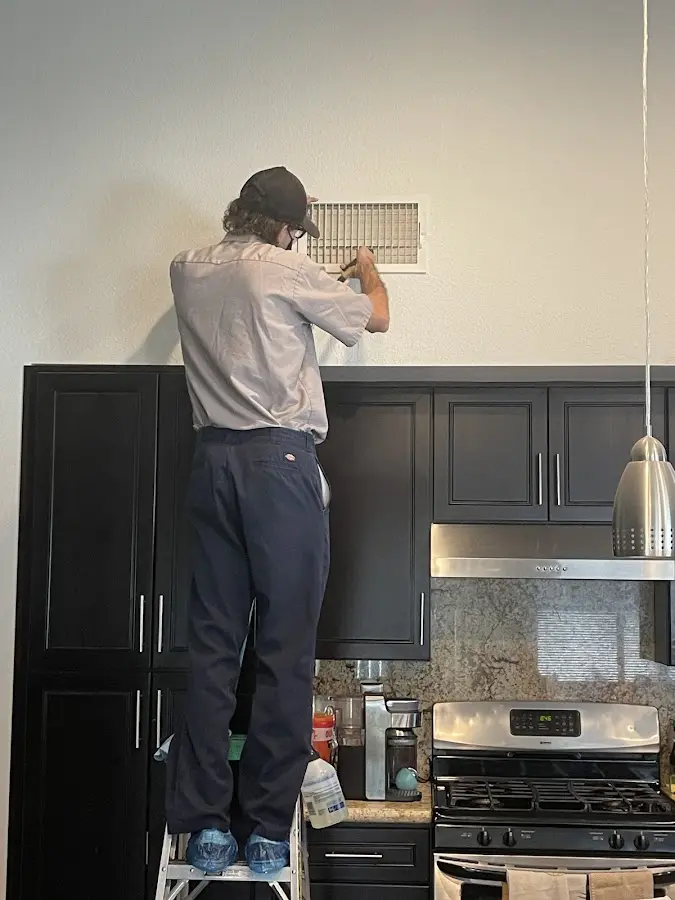 Technician inspecting an air vent during HVAC service in Palmetto